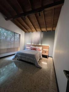 a bedroom with a bed and a large window at Luxury - Casa Shangri-la in Medellín