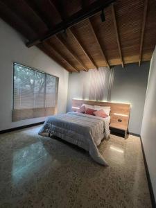 1 dormitorio con cama y ventana grande en Luxury - Casa Shangri-la, en Medellín