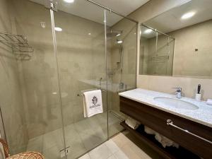 a bathroom with a glass shower and a sink at Myhome Avani Palm View Dubai in Dubai