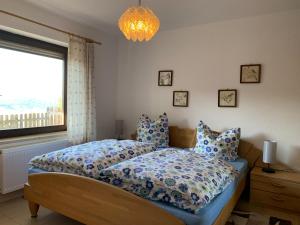 a bedroom with a bed and a window and a chandelier at Schönblick23 in Langfurth 