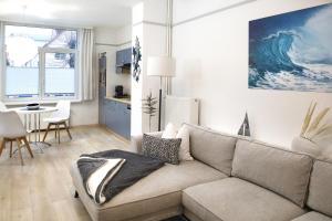 a living room with a couch and a kitchen at Haus der kurzen Wege in Warnemünde