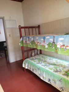 ein Schlafzimmer mit einem Etagenbett mit einer Bettdecke mit Tieren darauf in der Unterkunft Lazer Caraguatatauba ✓ in Caraguatatuba
