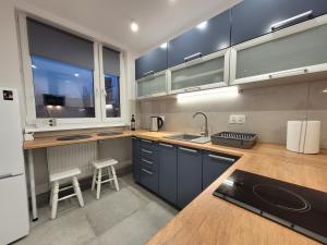 a kitchen with blue cabinets and a sink at Ludowa apartament in Biskupiec
