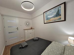 a bedroom with a bed and a clock on the wall at Ludowa apartament in Biskupiec