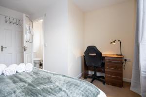 a bedroom with a bed and a desk and a chair at Beautiful 4 Bed House in Manchester Free Parking in Manchester