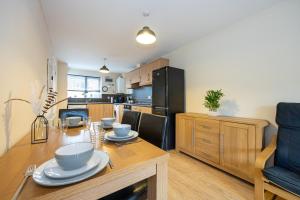 eine Küche mit einem Holztisch mit Geschirr darauf in der Unterkunft Beautiful 4 Bed House in Manchester Free Parking in Manchester