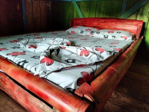 a bed with red flowers on it in a room at Sierra de viboral adventures in Medellín