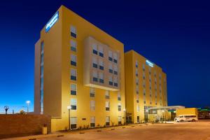 a yellow hotel with a sign on the side of it at City Express by Marriott Rosarito in Rosarito