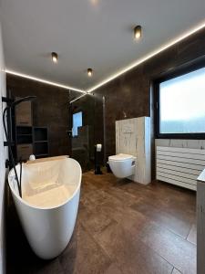 a large bathroom with a tub and a toilet at Architektenhaus am Waldrand mit Sauna in Schwabach