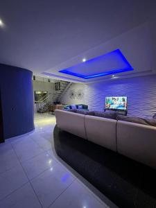 uma sala de estar com um sofá e um tecto azul em Blue Bell Suites em Lekki