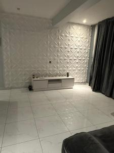 a living room with a white tile floor and a wall at Blue Bell Suites in Lekki