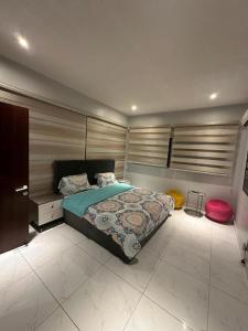 a bedroom with a large bed and a red stool at Blue Bell Suites in Lekki