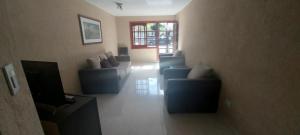 ein Wohnzimmer mit blauen Sofas und einem TV in der Unterkunft Dúplex Mar de Ajó in Mar de Ajó