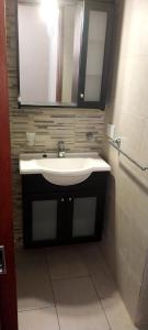 ein Badezimmer mit Waschbecken und Spiegel in der Unterkunft Dúplex Mar de Ajó in Mar de Ajó