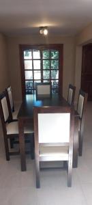 ein Esszimmer mit einem Holztisch und Stühlen in der Unterkunft Dúplex Mar de Ajó in Mar de Ajó + 3 Fotos