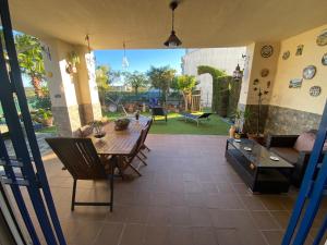 a living room with a wooden table and chairs at Costa esuri CASA TRINIDAD in Huelva