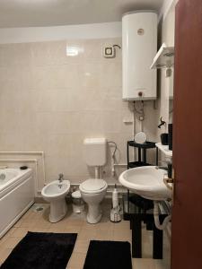un bagno con un water, un lavandino e una vasca di Jordan Apartman a Niška Banja