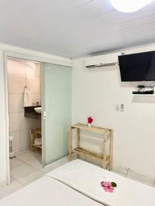 a living room with a television and a white wall at Terras Verdes Residence in Fernando de Noronha