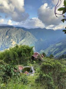 uma casa numa colina com montanhas ao fundo em Sierra de viboral adventures em Medellín