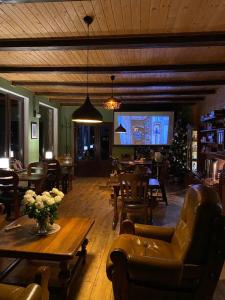 a living room filled with furniture and a large tv at AGORA Chalet in Slavske
