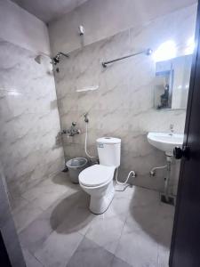uma casa de banho com um WC e um lavatório em Le Grace Annasalai em Chennai