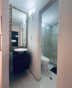 y baño con aseo, lavabo y ducha. en Apartamento Rodadero, en Santa Marta