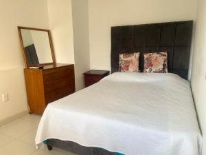 1 dormitorio con cama, tocador y espejo en Apartamento Rodadero, en Santa Marta