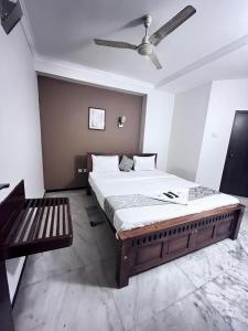 1 dormitorio con 1 cama grande y ventilador de techo en Le Grace Annasalai en Chennai