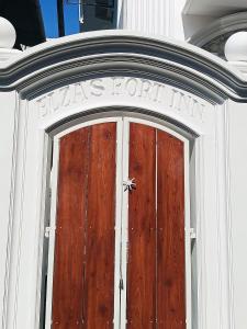 uma porta de madeira com uma placa por cima num edifício em ELZAS FORTINN Homestay Fortkochin,kochi em Cochin