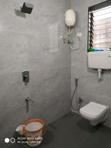 uma casa de banho com um WC branco e um lavatório. em Krushna Kunj Holiday Home em Alibaug