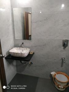 baño con lavabo y espejo en la pared en Krushna Kunj Holiday Home, en Alibaug