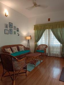 ein Wohnzimmer mit 2 Stühlen und einem Sofa in der Unterkunft Raaga on the Beach in Kannur