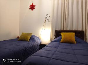 a bedroom with two beds and a star on the wall at APARTAMENTO URMA Cuzco in Cusco
