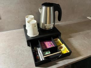 une cafetière assise au-dessus d'une table dans l'établissement Cit'Hotel Le Cheval Blanc Cognac Centre, à Cognac