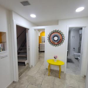 un couloir avec une table jaune et un escalier dans l'établissement Napoli Charme, à Naples