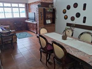 ein Wohnzimmer mit einem Tisch und Stühlen in der Unterkunft Casa do Mar in Guarapari