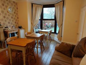 a living room with a table and chairs and a kitchen at Thorndene B&B in Hope
