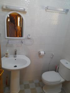 a bathroom with a sink and a toilet and a mirror at Studio meublé à Bel Air in Dakar