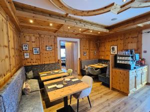 a restaurant with wooden walls and a table and chairs at Chasa Castello relax & spa in Samnaun