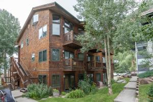 an apartment building with balconies and a tree at Cozy Tomboy Studio with private deck in Telluride