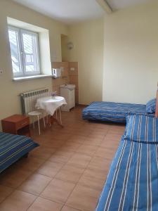 Zimmer mit 2 Betten und einem Tisch in der Unterkunft MeeMo 1 - hostel dla Firm in Łyszkowice