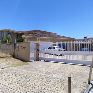 una cerca blanca frente a una casa en Harbour Close Home, en Ciudad del Cabo