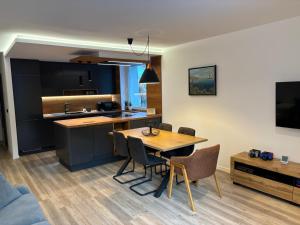 a kitchen and dining room with a table and chairs at Modern apartment Leon in Gozd Martuljek