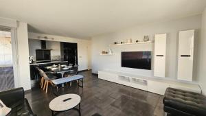 a living room with a tv and a dining room at Appart 3 chambres-Gare 1 min-Disneyland Paris 6 min in Bussy-Saint-Georges
