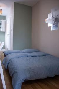 sypialnia z łóżkiem z niebieską pościelą w obiekcie Cosy apartment 7 mins walk from Wembley stadium w Londynie