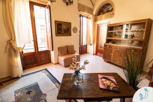 a living room with a table and a couch at Manno 81 - Charming historic apartment in Cagliari