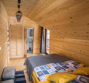 1 dormitorio con 1 cama en una habitación de madera en Chata Jazorna, en Liptovský Mikuláš