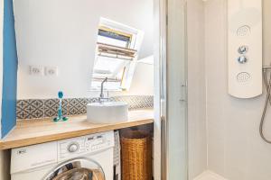W łazience znajduje się pralka i umywalka. w obiekcie Lovely apartment Paris Saint-Lazare Opéra w Paryżu +14 zdjęć