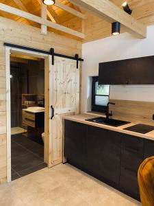 a kitchen with a sink and a wooden door at Radovna Chalet with Panoramic View in Mojstrana