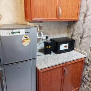 a kitchen with a white refrigerator and a microwave at العين الهيلي مصباح بيت 12 in Al Ain